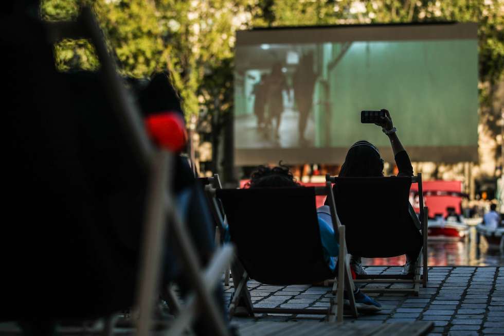 epa08554134 A woman takes a mobile picture for screening the French movie 'Le Grand Bain' in Cinema on the water at Paris Plages in Paris, Frence, 18 July 2020. Parisians attend the French movie 'Le Grand Bain' at the Cinema on the water after Paris Mayor Hidalgo launched the annual outdoor summer event Paris Plages on 18 July 2020. The temporary artificial beaches will run until 31 August 2020, with extra health precautions and instructions in place due to the ongoing pandemic of the COVID-19 disease caused by the SARS-CoV-2 coronavirus  EPA/MOHAMMED BADRA