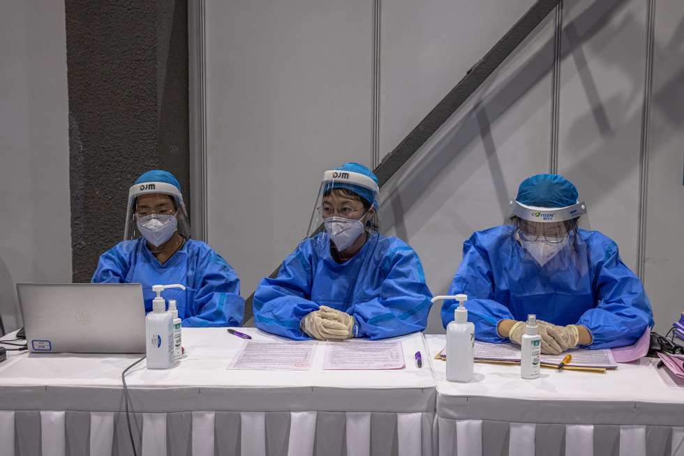 epa09091323 Health workers wait during a government-organized vaccination for foreigners against Covid-19 at a vaccination center, in Beijing, China, 23 March 2021. The vaccination was mainly organized for the foreign reporters working in Beijing and their family members.  EPA/ROMAN PILIPEY