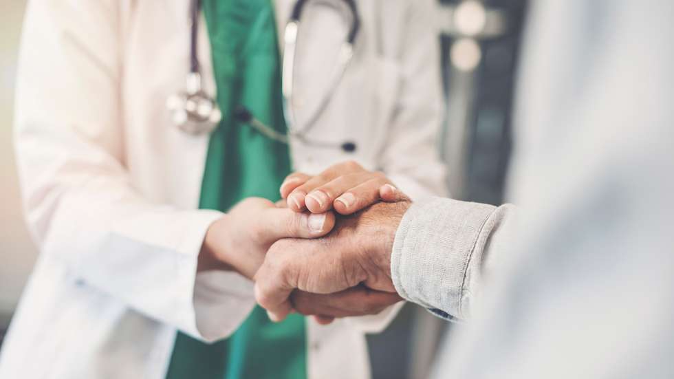 Médico segura mão de doente