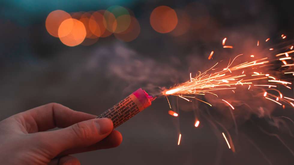 Low Angle View Of Hand Holding Firework Display