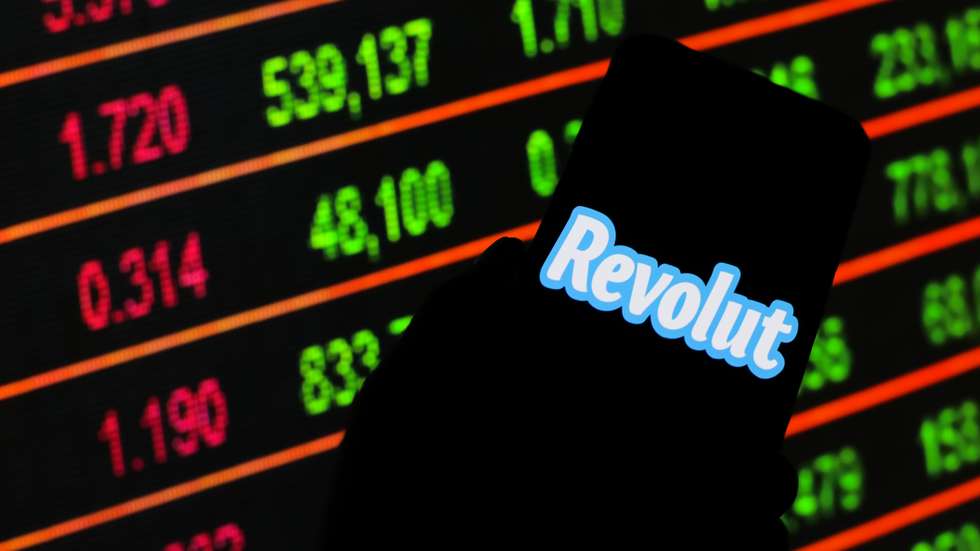 In this photo illustration a logo Revolut seen displayed on