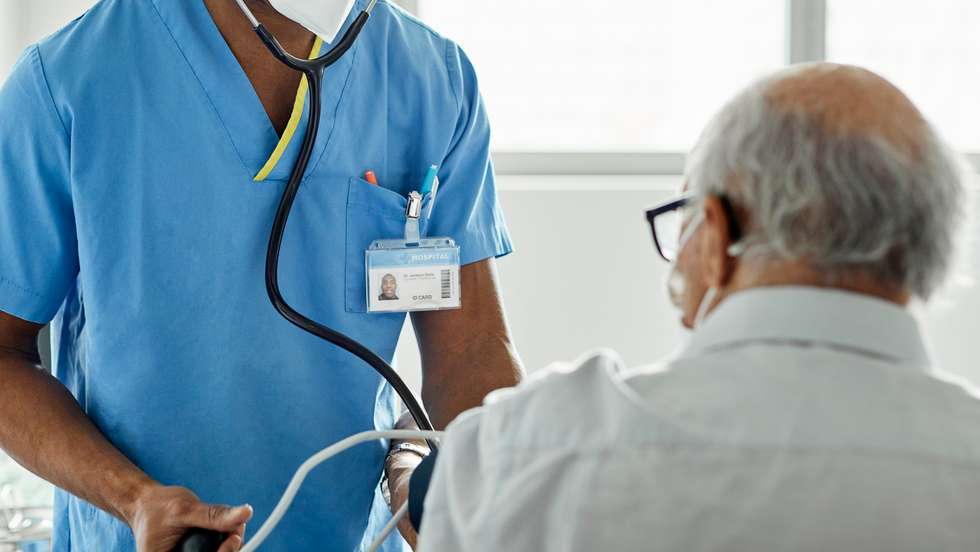 Nurse examining patient in clinic during COVID-19