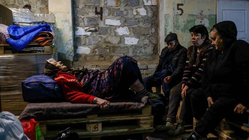 An injured woman lays on a wooden pallet inside the center