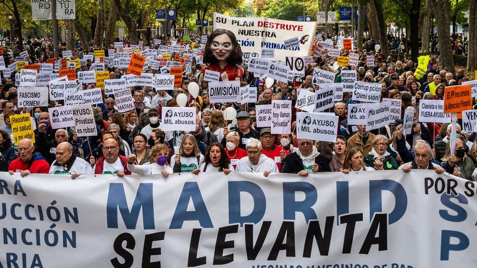 Protesters carrying a large figure of Isabel Diaz Ayuso,