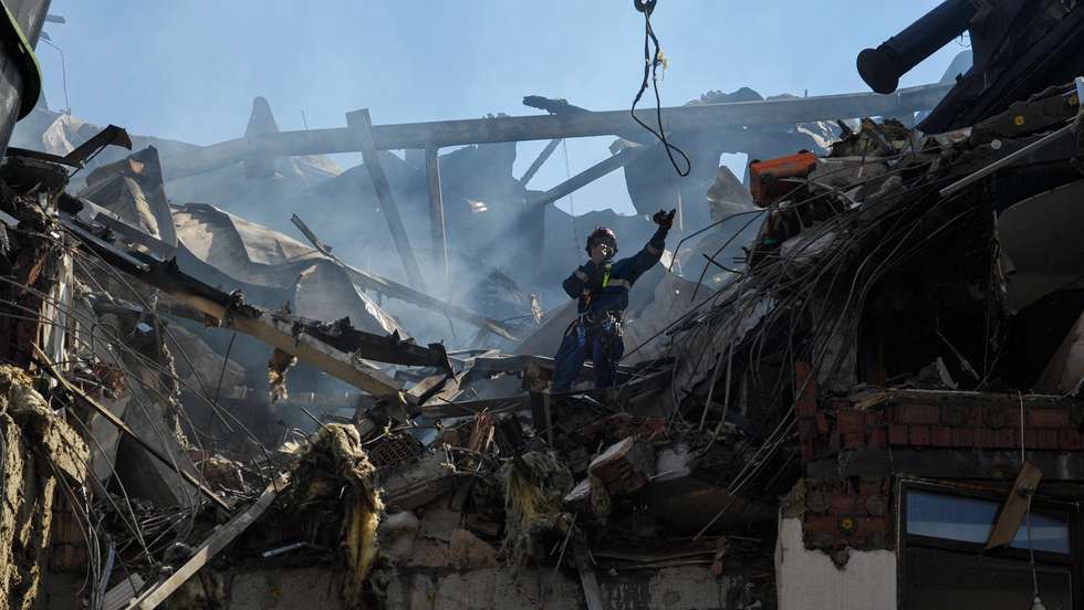 Rescuers work on a damaged residential building, as a result