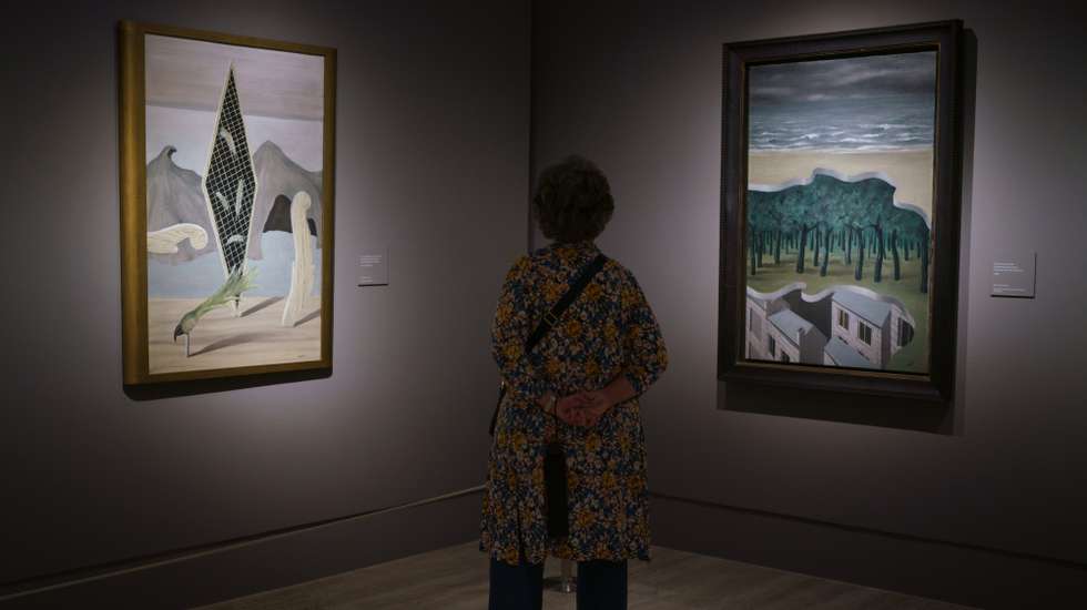 A visitor observes the works of the exhibition "The Magritte
