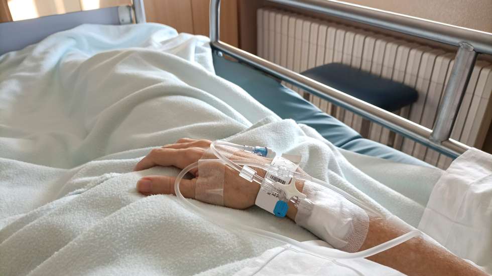 Midsection Of Patient With Iv Drip Relaxing On Hospital Bed