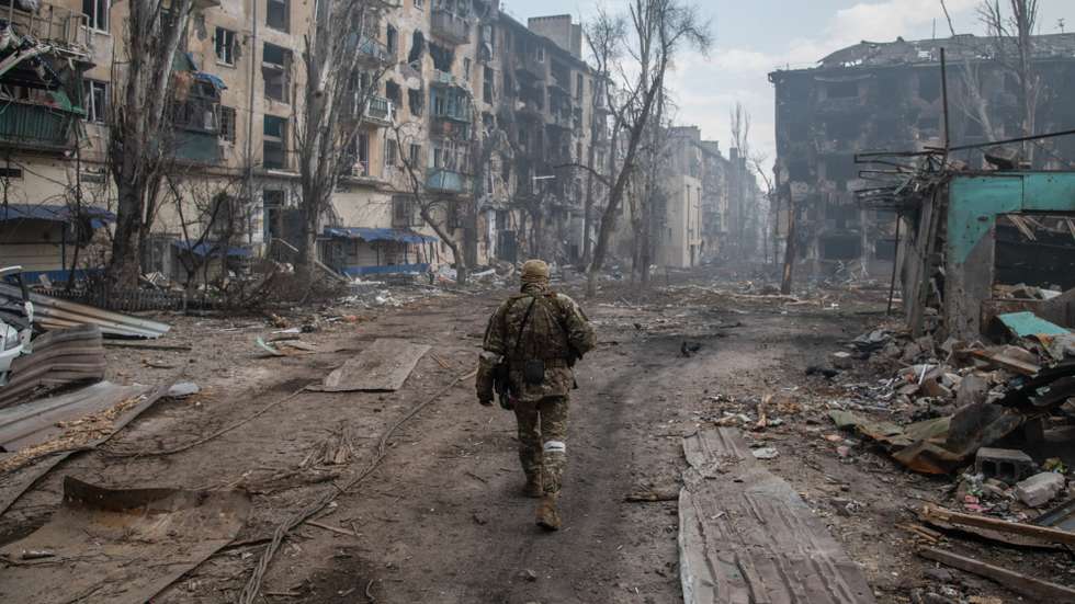 A Russian soldier walks amidst the rubble in Mariupol's
