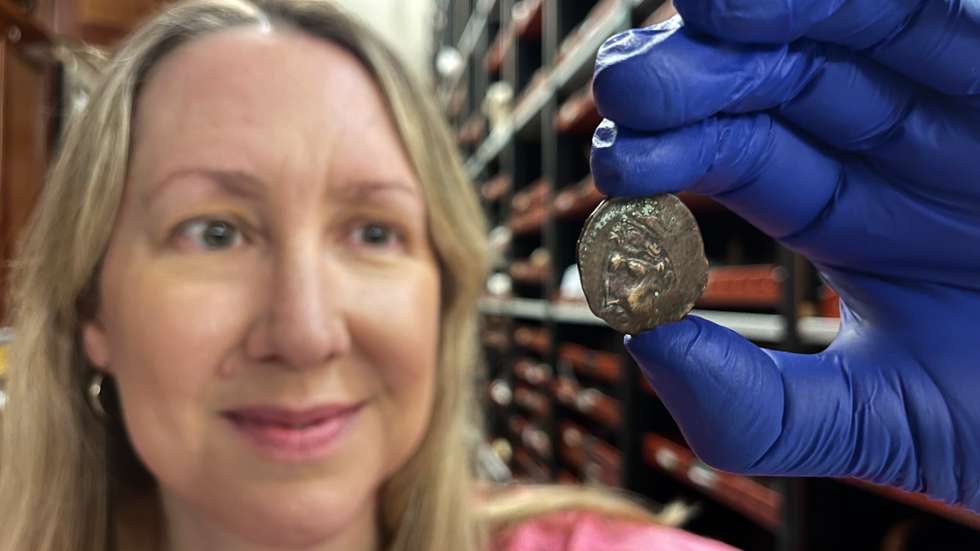 Kat Baxter, curadora de arqueologia e numismática dos Museus e Galerias de Leeds, com a moeda antiga agora em exibição no Centro de Descobertas de Leeds