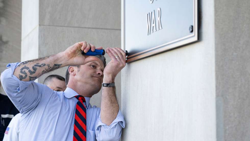 O Secretário da Guerra, Pete Hegseth, finaliza a instalação de uma placa do Departamento de Guerra na entrada do rio, em frente ao Pentágono, em 13 de novembro de 2025