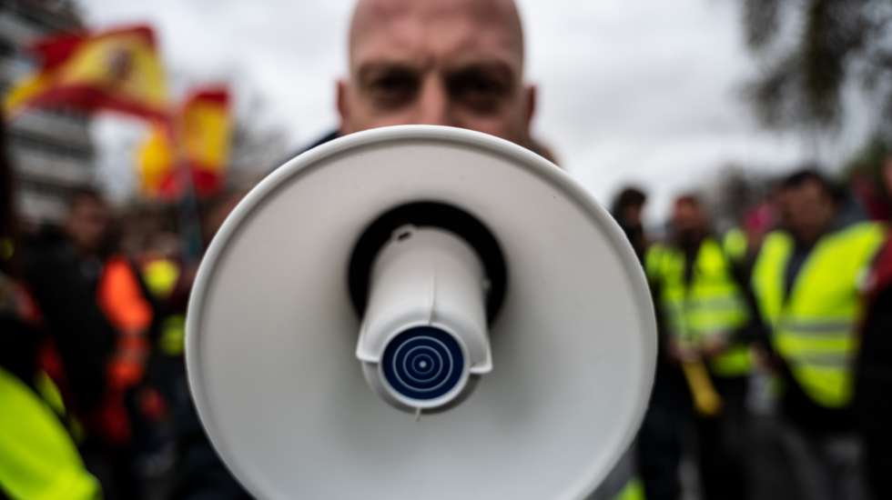 A truck driver is seen protesting with a speaker cone near