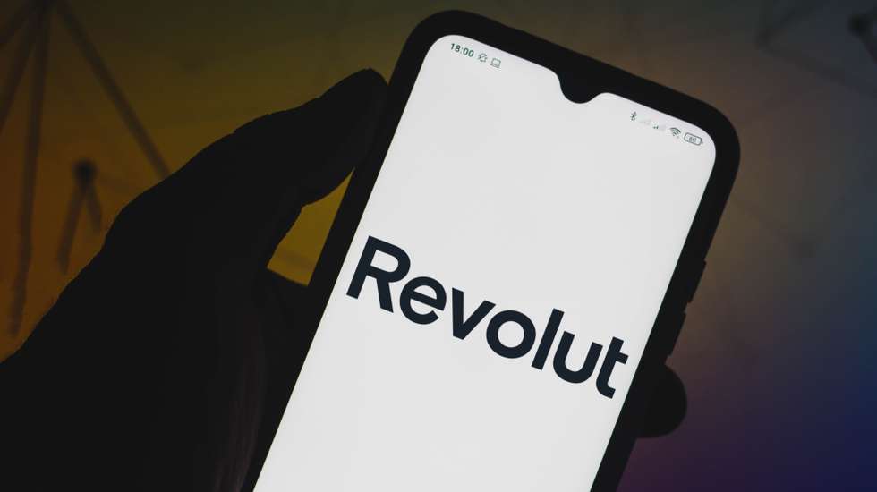 In this photo illustration a Revolut logo seen displayed on