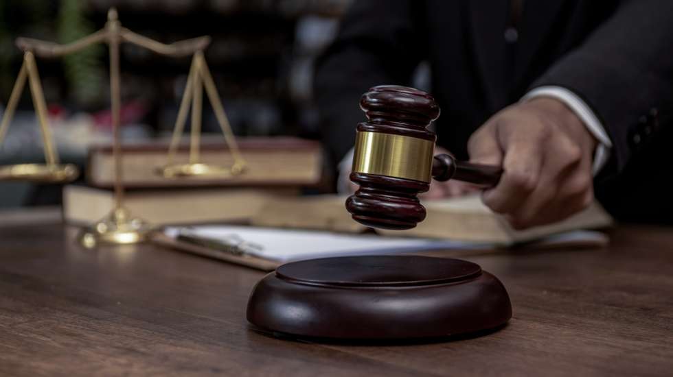 Man hand knocking a wooden judge gavel, law and auction concept.
