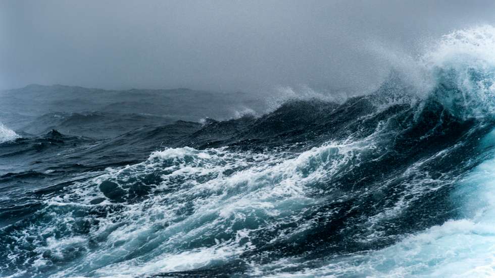 Breaking wave on a rough sea against overcast sky