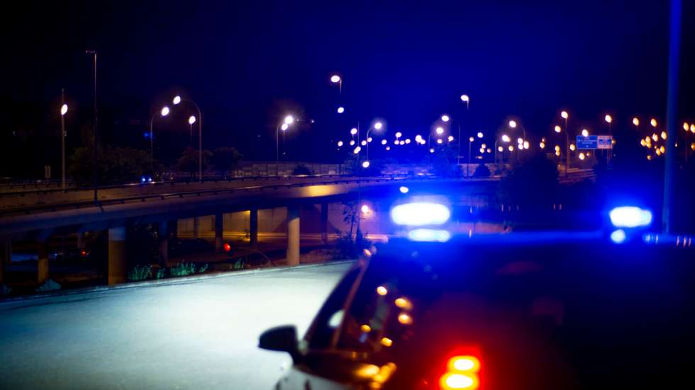 Police car with bright sirens and the city in the background