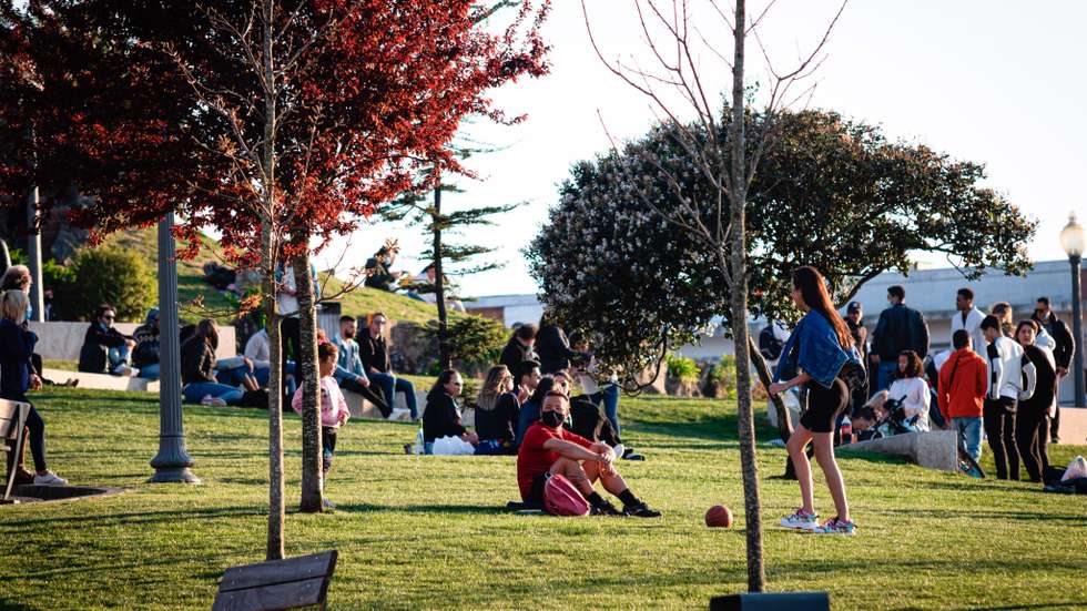 People enjoy the warm weather at Jardim do Morro amid
