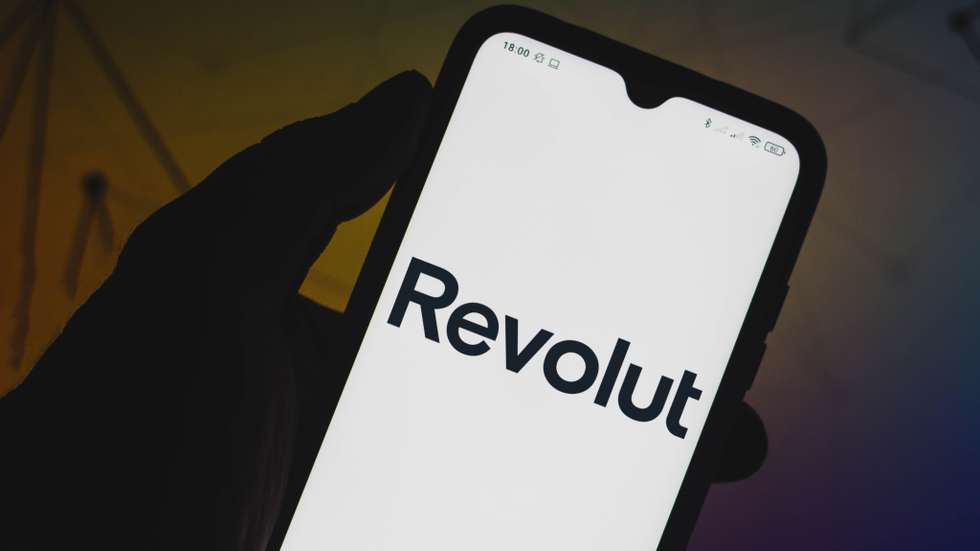 In this photo illustration a Revolut logo seen displayed on