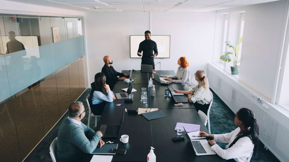 High angle view of businessman giving presentation colleagues in board room at office