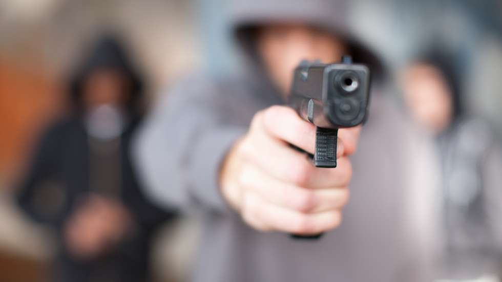 Man with gun pointed at viewer