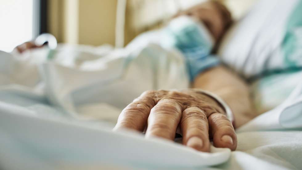 Senior woman wearing face mask lying on hospital bed