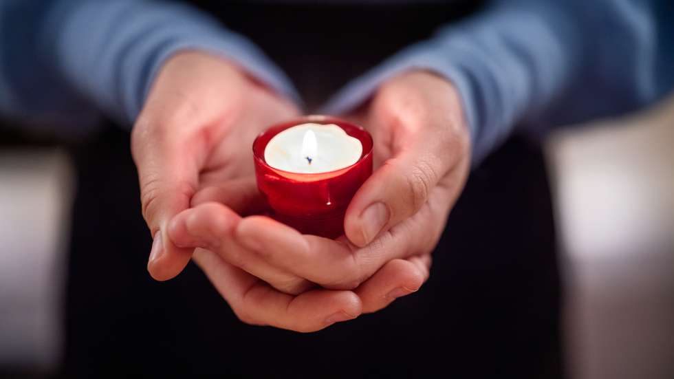 Close-up of woman holding a votive candle