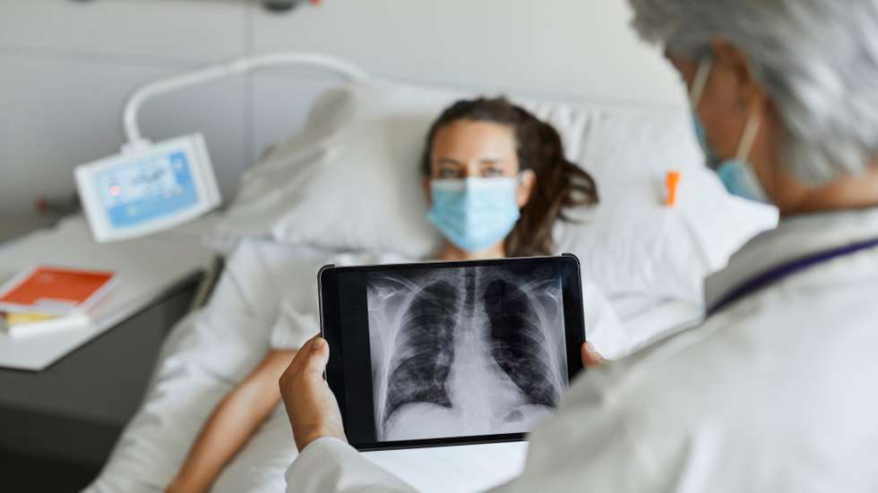 Doctor with digital x-ray by patient in ICU