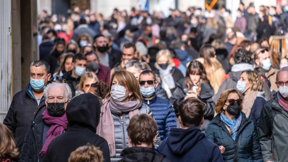Crowds of people wearing facemasks are seen in the Portal d'