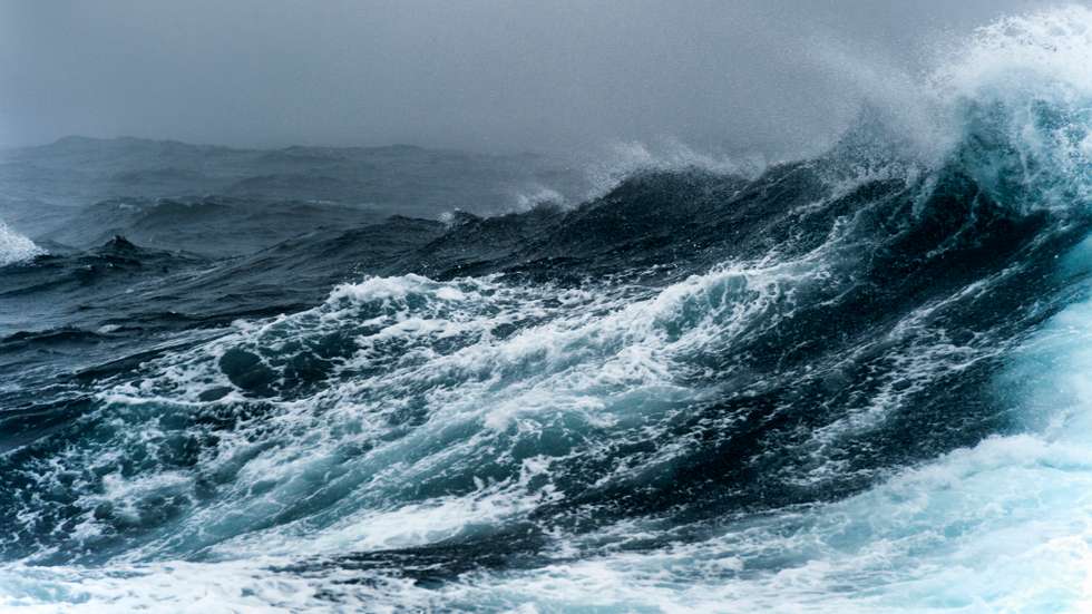 Breaking wave on a rough sea against overcast sky