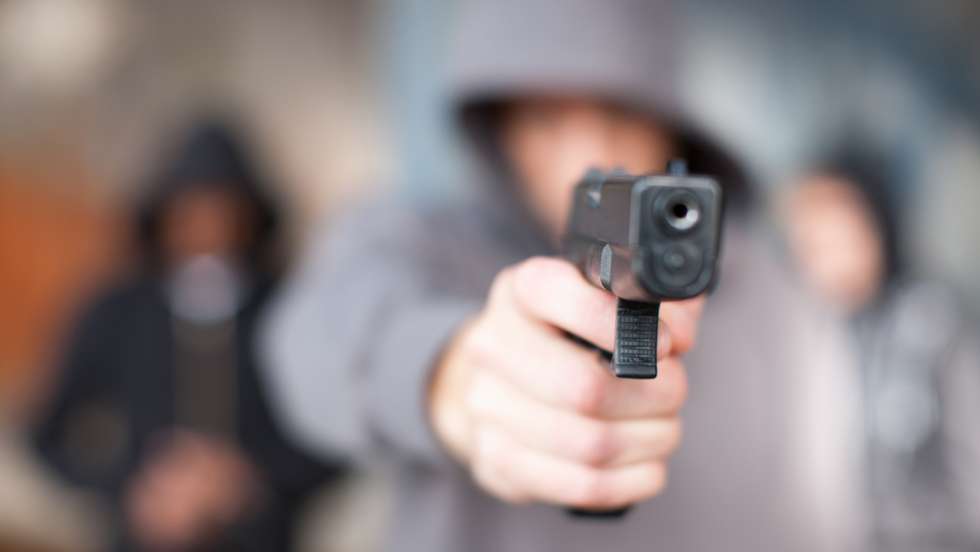 Man with gun pointed at viewer