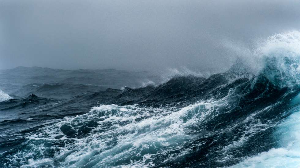 Breaking wave on a rough sea against overcast sky