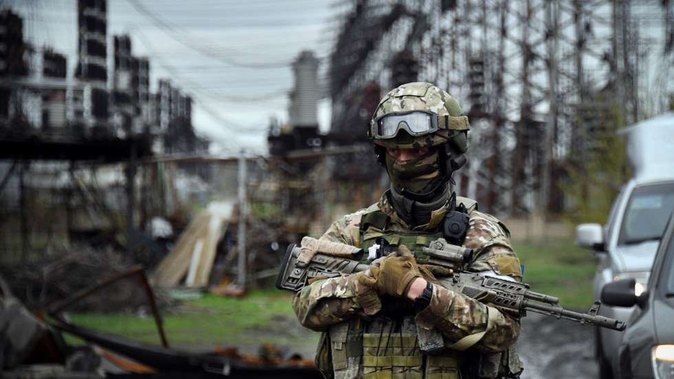In this picture taken on April 13, 2022, a Russian soldier stands guard at the Luhansk power plant in the town of Shchastya.