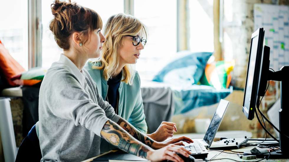 Two businesswomen working on a computer