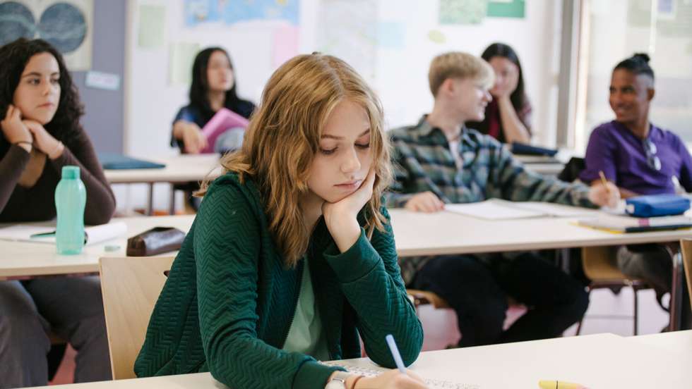 Student Concentrating While Working In Classroom