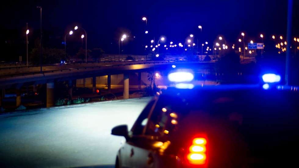 Police car with bright sirens and the city in the background