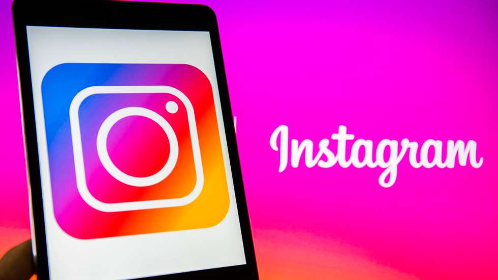 Young man holds a smart device while using Instagram app