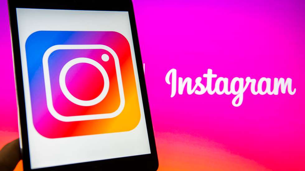 Young man holds a smart device while using Instagram app