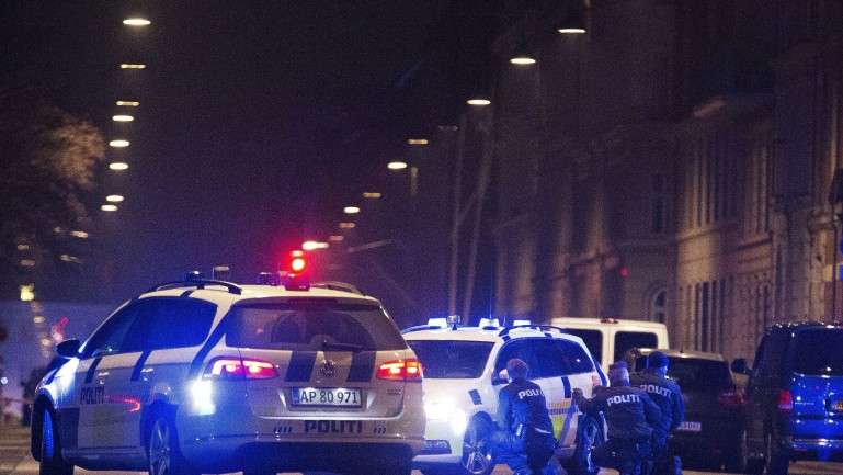 Polícias protegem-se atrás das suas viaturas nas ruas do centro de Copenhaga, a 15 de fevereiro de 2015, depois de uma pessoa ter sido baleada na cabeça e dois polícias terem sido baleados no braço e na perna
