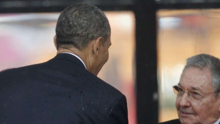 Obama e Raúl Castro cumprimentam-se durante o funeral de Mandela, em dezembro de 2013