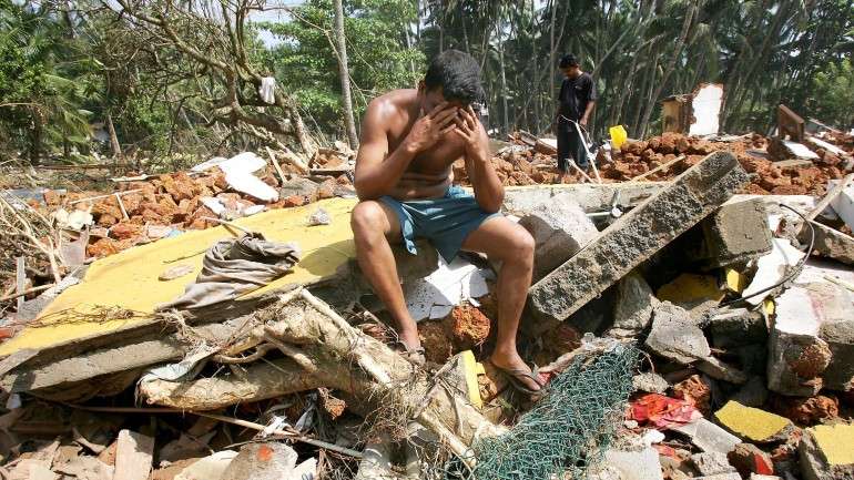 Um sobrevivente sobre os destroços da sua antiga casa