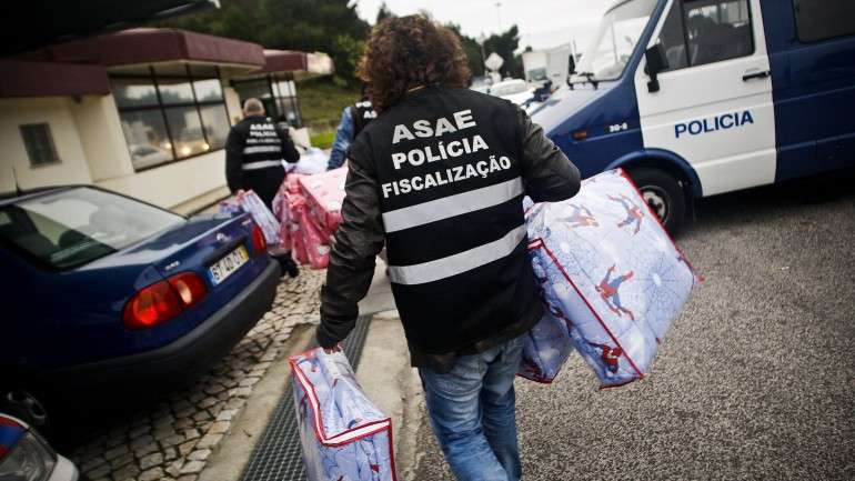 Entre o material apreendido constam malas/carteiras de diversas marcas de luxo, etiquetas, cintos e chapas com o nome das marcas