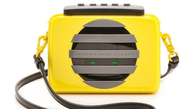 Tem play e abre sem ser preciso carregar no eject, só não dá música. Parece um walkman mas é uma clutch Marc by Marc Jacobs, para segurar na mão ou levar ao ombro. Preço: 345€