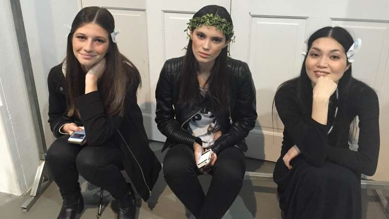 As manequins ocupam o tempo no backstage.