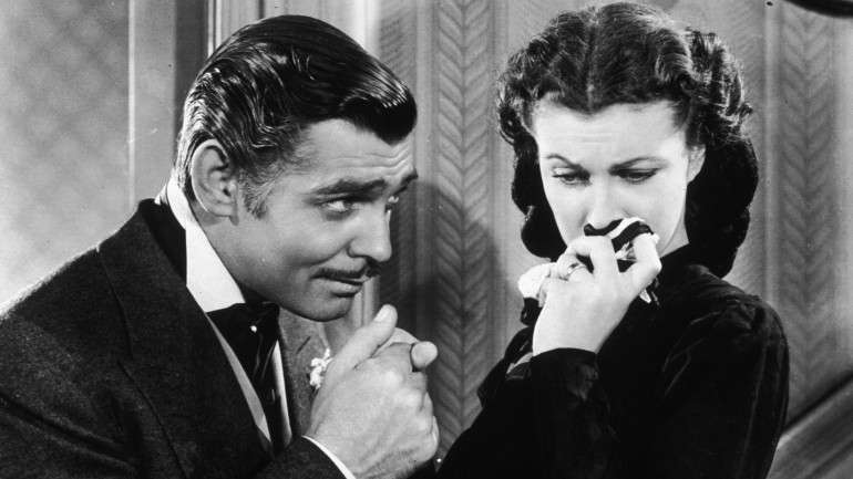 O ator norte-americano Clark Gable a protagonizar Rhett Butler, a beijar a mão de Scarlett O'Hara (desempenhada pela atriz britânica Vivien Leigh) no filme "E tudo o vento levou"
