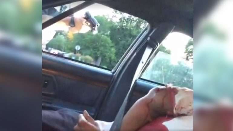 O agente da polícia manteve uma arma apontada ao homem, ferido, dentro do carro