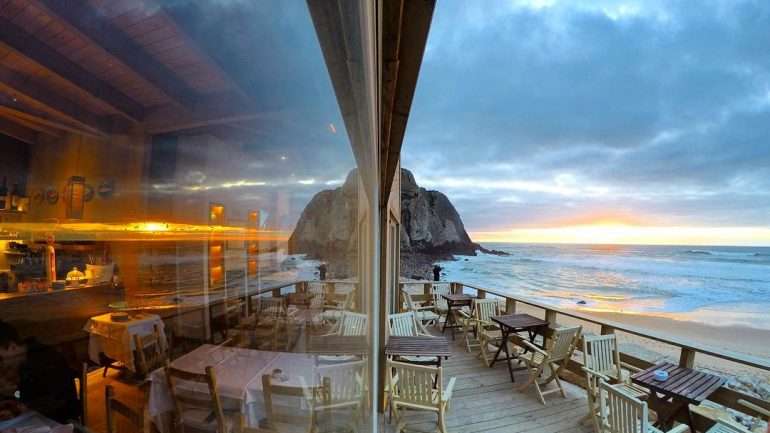 Quem vai à Praia Grande, perto de Sintra, não tem de inventar mundo: no respetivo Bar do Fundo há, além desta vista, marisco fresco, petiscos diversos e pratos mais substanciais.
