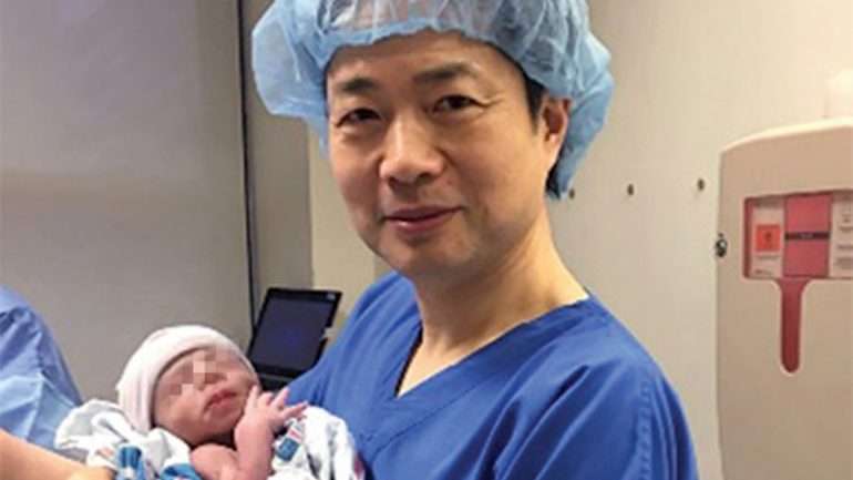 John Zhang segura o bebé com o ADN de 3 pessoas diferentes ao colo