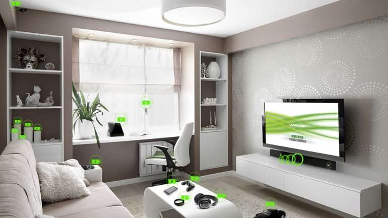 Uma imagem conceptual do carregador, debaixo da televisão, a carregar vários aparelhos eletrónicos numa sala.