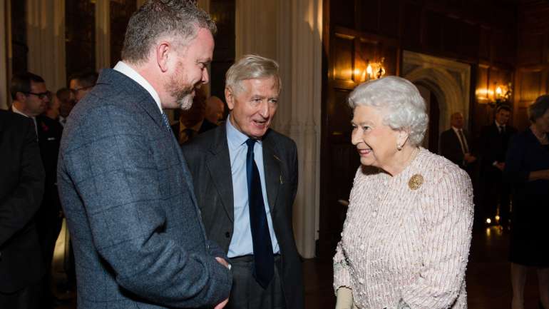 Christopher Moran (ao centro) com a Rainha Isabel II