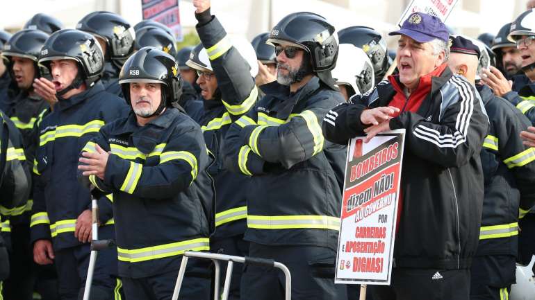 Os manifestantes levantaram cartazes nos quais se lia "bombeiros dizem não ao Governo por carreiras e aposentações dignas"