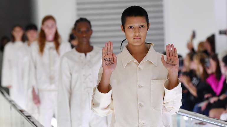 Ayesha Tan-Jones levantou as mãos durante o desfile da Gucci, em Milão. Nelas, leu-se "Saúde mental não é moda"